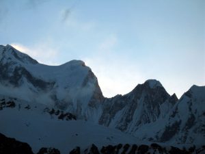 The glow of the sunrise highlighted clouds and blowing snow.